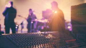 Soundman working on the mixing console in concert hall